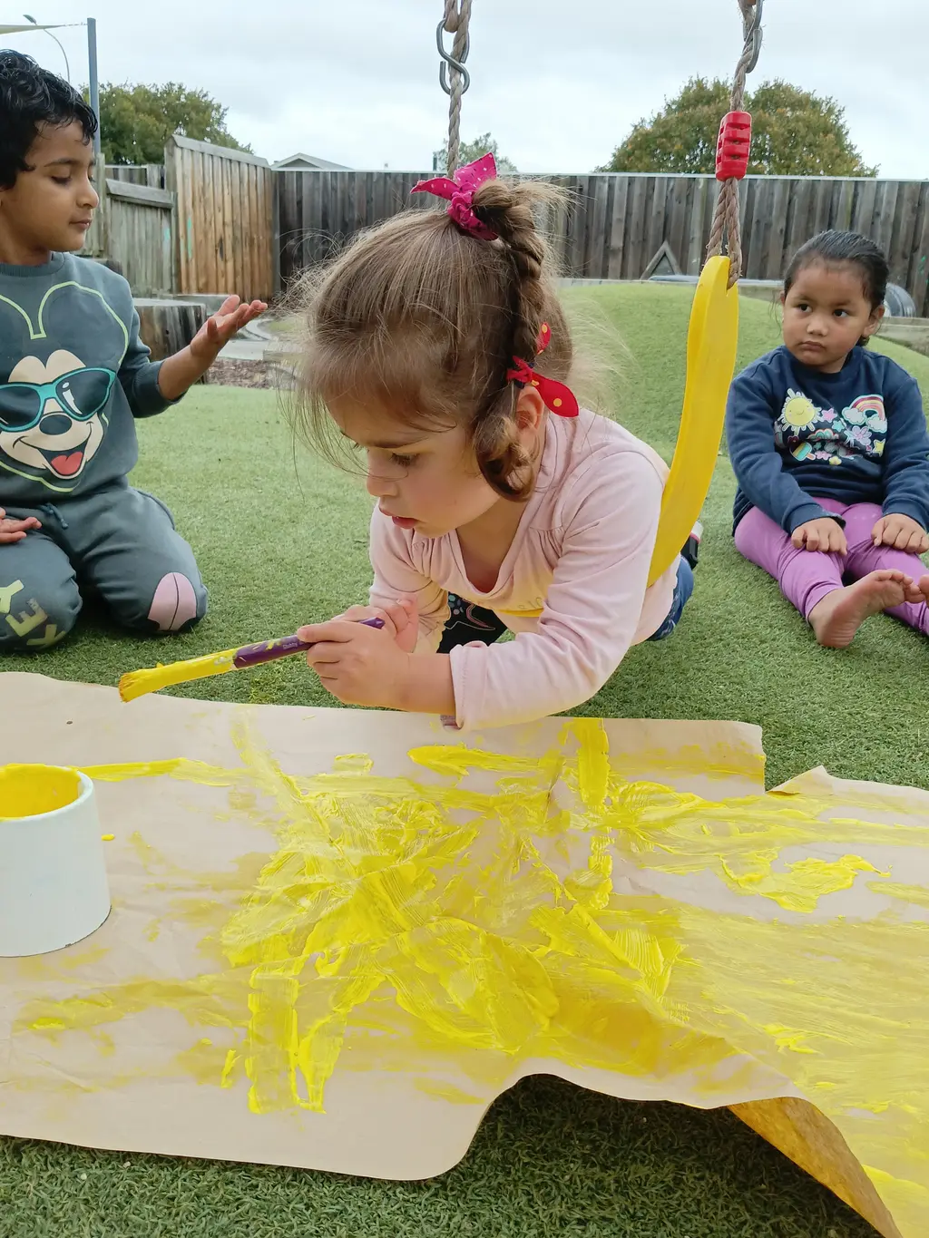 Children painting together outdoors at Highfield Haven