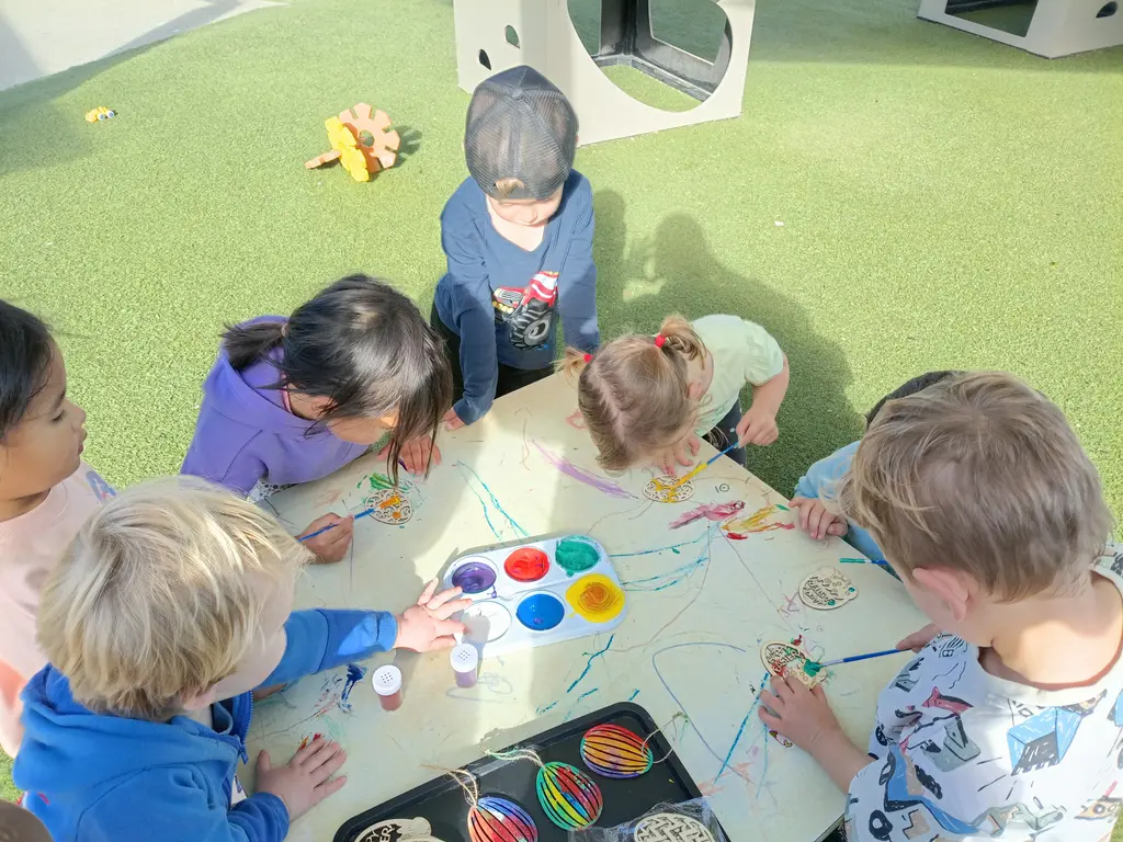 Children painting together outdoors at Highfield Haven