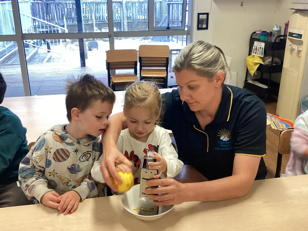 Kaiako supporting children with a hands-on cooking activity at Highfield Haven