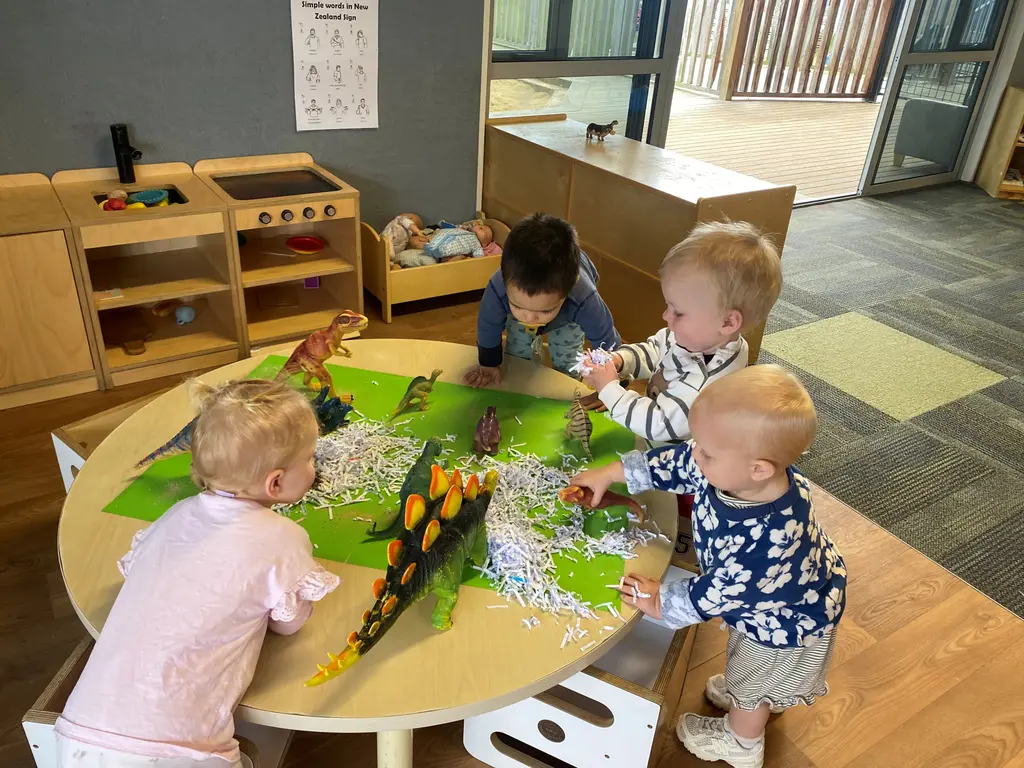Under-two children exploring sensory dinosaur play at Highfield Haven